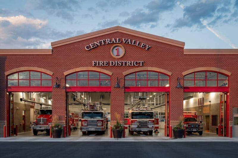 The exterior of the Central Valley Fire District station with fire trucks parked in its open bays